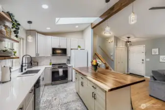 Chef's kitchen with updated cabinets, quartz counters, stainless appliance, bev fridge and show stopping butcher block island!