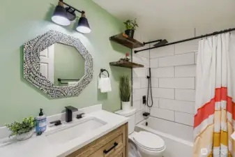 Stunning updated main bath with new tile backsplash, rain shower head, vanity and designer touches