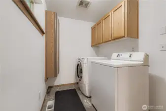 Spacious laundry room with built in storage and cabinets