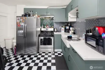 Unit #2011: Fresh kitchen updates create an efficient workspace. The basement access door is visible in the far left of the photo.