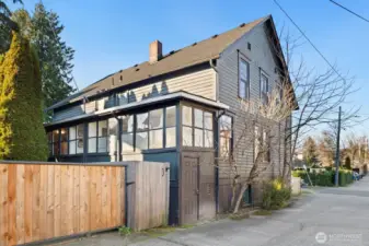 Corner lot with alley access - this shot shows the rear of Unit #2015, with external door and gated (gray fence) access to the yard. (The bright wood gate is part of neighboring property.)