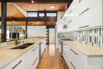 Sleek chef’s kitchen with quartz countertops under beautiful clearstory windows...
