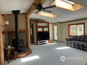 Large living room with skylights, new carpet and woodburning stove.