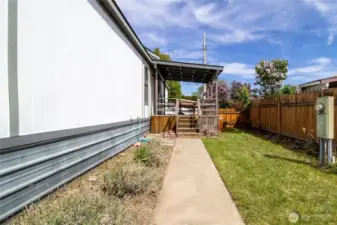 backyard with garden space and path to front deck
