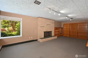 Lower level rec room. High ceilings and fireplace.