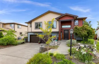 The home’s curb appeal shines with a blend of modern and natural textures—contrasting siding, stone accents, and mature landscaping frame this welcoming Birch Bay residence with a two-car garage.
