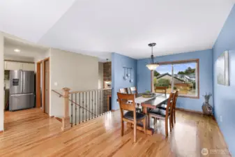 This alternate dining room perspective highlights architectural details like wrought-iron stair railings and wood trim, blending warmth with elegance and guiding the eye through the home’s fluid floor plan.