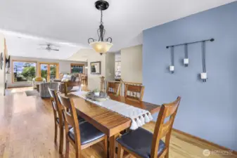 The dining area exudes character with its striking blue accent wall, statement chandelier, and natural wood finishes. Positioned between the kitchen and living space, it’s ideal for everyday meals or weekend gatherings.
