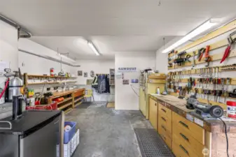 The well-equipped workshop is a dream for hobbyists or professionals alike, offering wall-to-wall storage, pegboard tool organization, and ample work surface