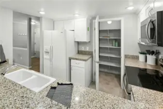 Crisp white Shaker-style cabinetry, and a spacious walk-in pantry offer style and storage.