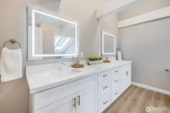 Large dual-vanity setup offers ample storage, quartz countertops, and everyday functionality designed for busy households.