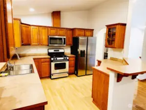 Open kitchen with breakfast bar and brand new sink and refrigerator