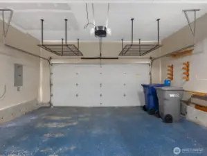 View from entry of garage to car door, overhead storage system stays with home to help keep organized & accessible