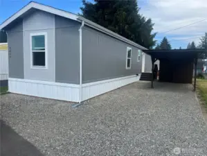 Side view of the home with carport and shed.