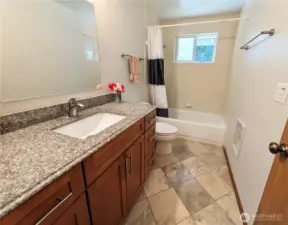 The guest bath has a tub and shower with tile surround. Conveniently located between the great room and the two extra bedrooms.