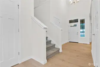 Entry way with high ceilings and hardwood flooring. Photo for illustration only of similar home, not actual.