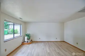 Living room with vaulted ceiling and plenty of natural light.