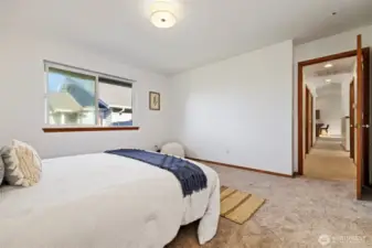 Looking back down the hall to the living room and two additional bedrooms.
