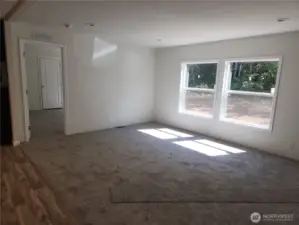 Another angle to the open concept living area, kitchen is on the left side of photo and door in photo is to the strategically placed primary for more privacy.