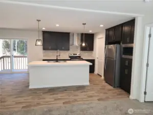 Wonderful contemporary style kitchen with sleek black cabinetry, stainless steel appliances and copper tone hardware on the cabinets.
