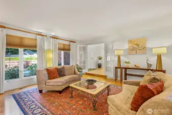 Another view of the living room highlights the natural flow into the foyer and beyond. The French doors and tall windows make this a versatile and open space, ideal for welcoming guests or enjoying a quiet moment at home.