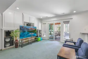 On the lower level, a large recreation room opens to the outdoors, combining built-in storage, generous square footage, and direct access to the patio for seamless indoor-outdoor living.