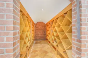A dedicated wine cellar with custom wood racks and brick accents adds character and provides ideal storage for collections.