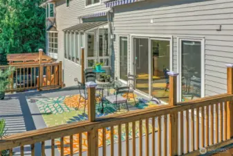 The expansive deck provides abundant room for outdoor dining and lounging. Surrounded by greenery, it creates a natural extension of the home’s living space.