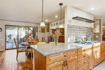 Wonderful kitchen with granite countertops and tiled backsplash behind the gas cooktop.