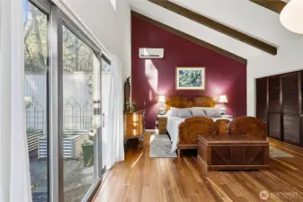 Primary bedroom has a king-sized bed, the same engineered hardwood as in the rest of the house, sliding doors to the courtyard and a large closet space.