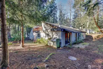 The side of the house houses the two propane tank that fuel the two fireplaces and the cooktop. The deck railing is for the flat roof.