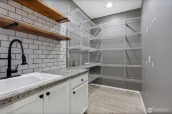 enormous walk in pantry accompanied by a farmhouse sink