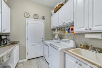 The laundry room is super functional with lots of storage, a utility sink and handy counter.
