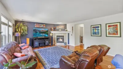 Warm hardwood flooring and a charming gas fireplace make this living room feel instantly inviting. Tucked nearby are the garage entrance and laundry area — complete with included washer and dryer for added convenience