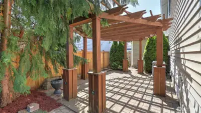 An impressive pergola creates an inviting area for gatherings, protected from direct sunlight while still feeling open to the outdoors