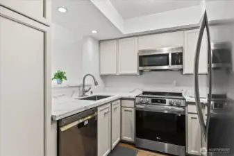 light and bright kitchen with SS appliances and large pantry cabinet.