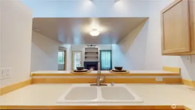 Looking into the living room and dining room.  The Gas log fireplace adds so much warmth and ambiance to the home!  The raised breakfast bar allows for a break between the formal and informal.  You are never separated from your guests and your prep areas are not visible from the dining or livingroom areas.