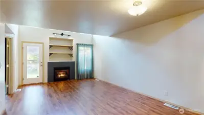Looking through the Livingroom area at the natural gas log fireplace and the door that leads to the entertainment patio and fully fenced back yard.