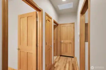 Wide upper hallway accented by beautiful wood doors.