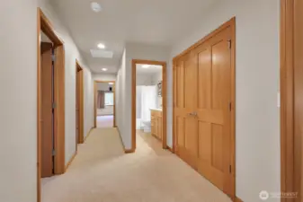 Well-designed upper hallway with warm wood doors and natural flow between rooms.