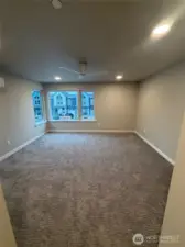 Primary bedroom with ceiling fan & flooded with natural sunlight