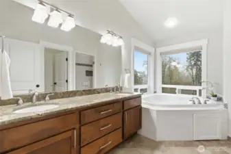 Second floor primary bath, featuring two sinks, soft close drawers, granite countertops, and vaulted ceilings.