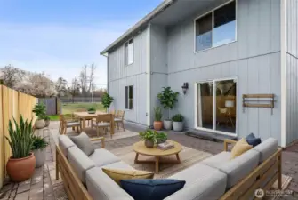 Large paved patio extends the length of the house. It has been virtually staged to help you envision your usagae of the space. And, no neighbors on one side with the pond. Home also has A/C and security system with cameras.