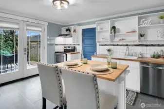 Beautifully updated kitchen with tile floors, open shelving, and tile backsplash.