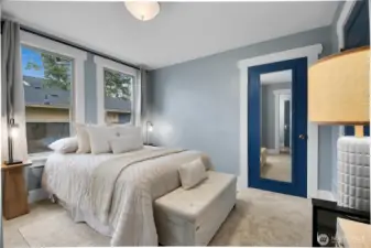 Main-floor primary bedroom featuring large windows, a walk-in closet, and brand-new carpet!