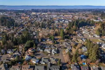 West facing Aerial shows water of Vancouver Lake Park in left distance. In front of that are groceries, theaters, big box and smaller stores on both sides of I-5 between 78th St and 99th St including at Hazel Dell Marketplace