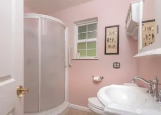 Bathroom with a walk in shower on the main level next to office space.