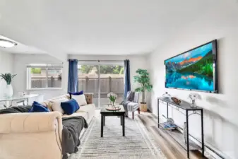 The bright and airy living room opens to a generous, fully fenced patio for outdoor living.