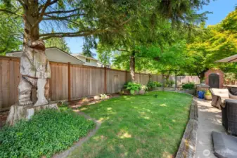 Upper garden/yard space is awesome. Not only does it provide shade, it features Bear and fish carving. Bear and fish look over the hard and keep an eye on all the happenings. Notice the above ground sprinkler...it stays.