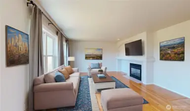 Warm and inviting family room filled with natural light from large windows. Beautiful hardwood floors flow throughout the space and a double-sided gas fireplace with a custom mantel serves as the focal point, adding both charm and functionality. Photo is virtually staged.